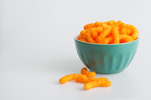 Cheese stiks in a green bowl on a white background