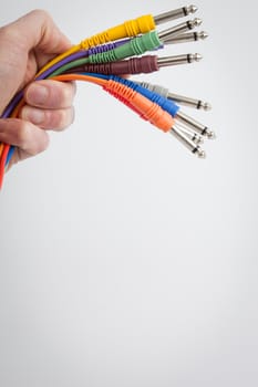 Hand holding color wires on a white background