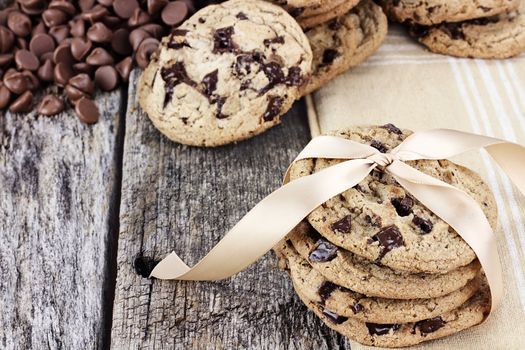 Fresh homemade chocolate chip cookies with chocoate chips and more cookies in the background. Shallow depth of field. 
