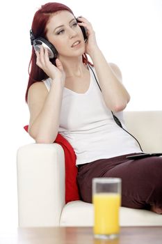 Happy smiling young woman listening to music at home on headphones