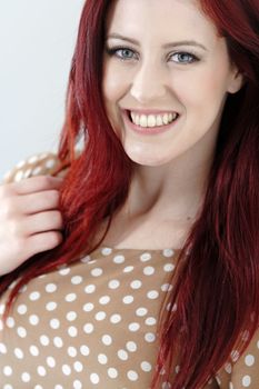 Happy smiling young woman with long red hair