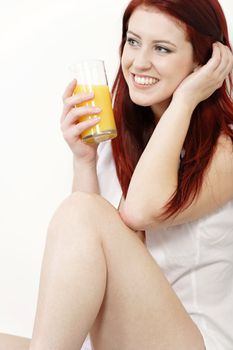 Beautiful young woman in white shirt and underwear enjoying some breakfast Orange juice.