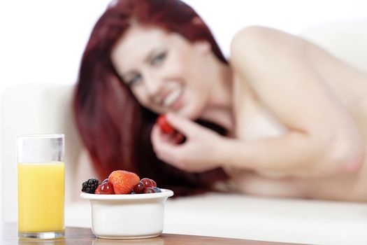 Fresh fruit and Orange juice on a coffee table with sexy woman in the background