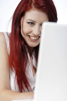 Happy young woman using a laptop at home