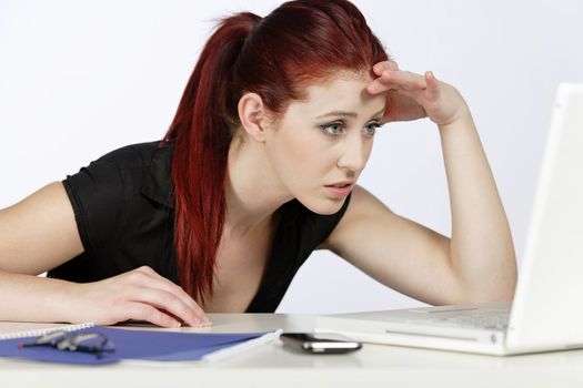 Professional woman showing concern at work using her laptop