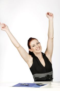 Professional young woman celebrating at work in her office