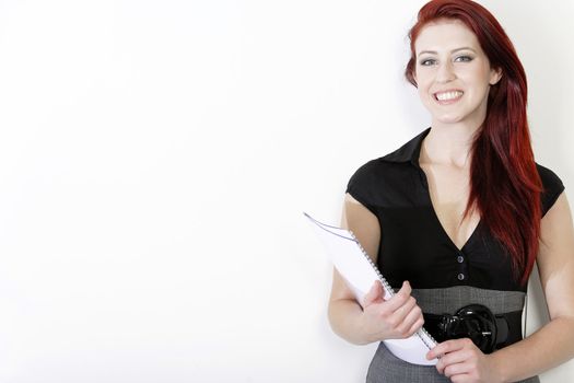 Professional young business woman in a smart dress holding folders and documents