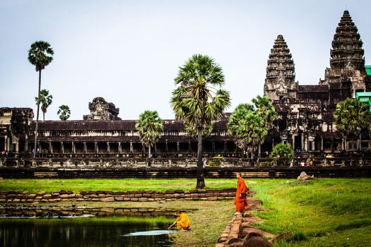 SIEM REAP, CAMBODIA - CIRCA JUNE 2012: Unidentified buddhist monk standing on the edge of the pool circa June 2012 in Angkor Wat, Cambodia The monastery is still use as part of worship sacred place.