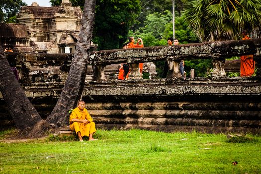 SIEM REAP, CAMBODIA - CIRCA JUNE 2012: Unidentified buddhist monk standing on the edge of the pool circa June 2012 in Angkor Wat, Cambodia The monastery is still use as part of worship sacred place.