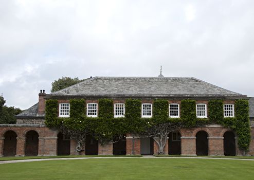 A brick built collonade covered in Magnolia in the grounds of an English stateley home