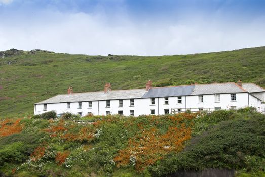 Seaside Cottages in Cornwall England on a hillside with orange crocosmia flowers