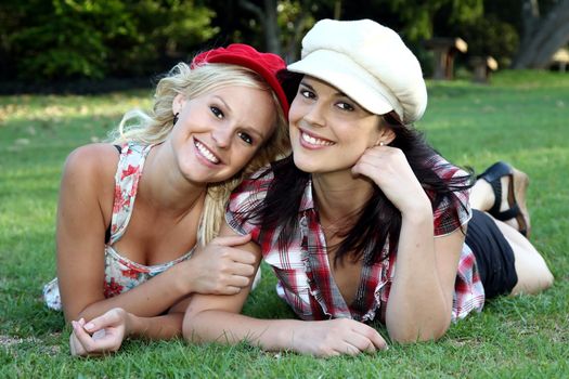 Two gorgeous smiling young women friends in caps