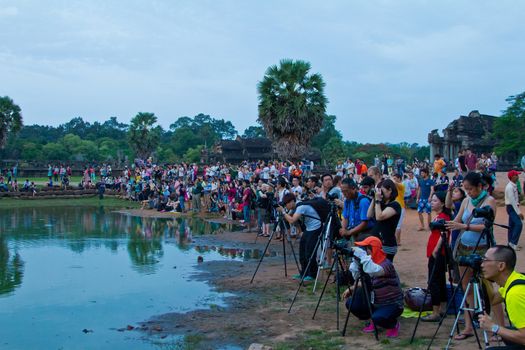 SIEM REAP, CAMBODIA - CIRCA JUNE 2012: unidentified photographers setting up their equipments at sunrise in front of the reflection pool/pond at Angkor Wat circa June 2012 in SIEM REAP, CAMBODIA. Low season from April to October see lower number of tourist at Angkor.