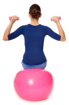 Instructor taking exercise class using ball and dumbbells at gym