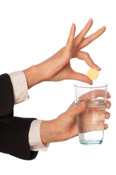 Businesswoman throws a pill from headache to the glass with water