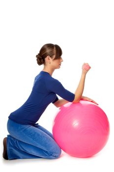 instructor showing exercises using ball and dumbbells at gym to people