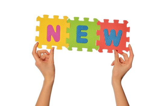 teacher holding in the hand the amusing colored educational puzzles with the word new