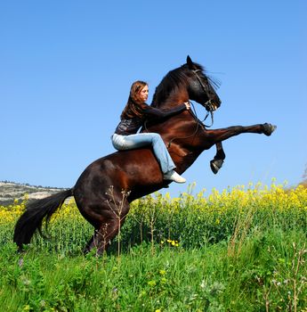 young woman and her beautiful black stallion rearing up