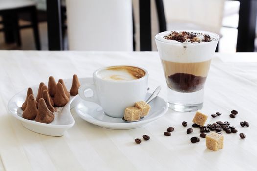 Appetizing coffee and sweets on a table in modern cafe