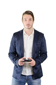 Young man playing videogames with joypad or joystick, standing and isolated on white