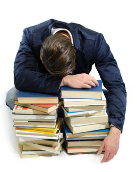 Young student sleeping on piles of books, isolated on white