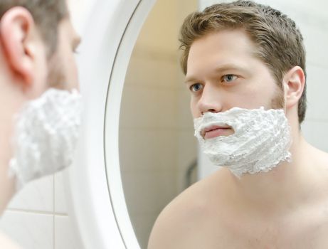 Man preparing to shave, foam on face