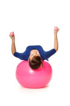 Instructor taking exercise class using ball and dumbbells at gym