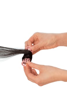hairdresser makes curls on the woman's black hair