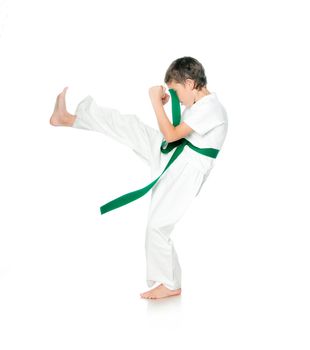 Boy in kimono with green belt practising  on a white background