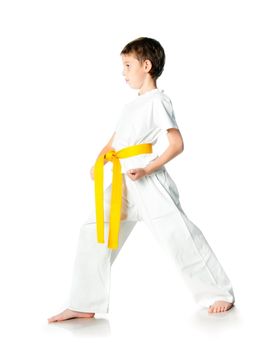 Young boy in kimono with yellow belt  on a white background