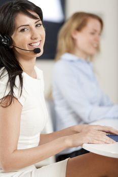 Two colleagues working in a busy call centre office.