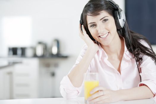 Young woman listening to music with headphones at home.