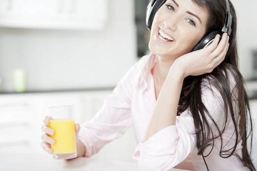 Young woman listening to music with headphones at home.