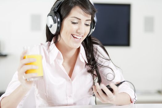 Young woman listening to music with headphones at home.