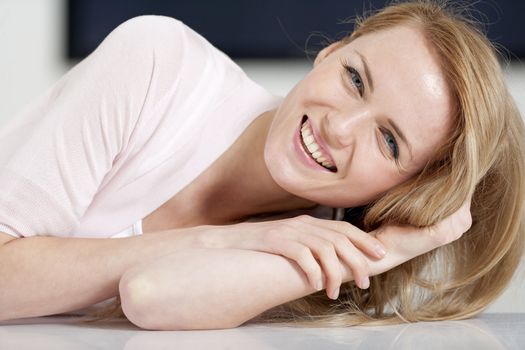 Young woman in pink shirt sitting at dining table at home