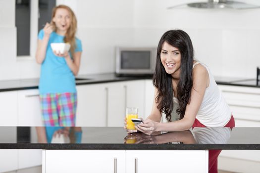 Two young woman having juice and breakfast at home