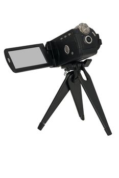 Video camera with the viewfinder screen extended attached to a small tripod for stability isolated on white