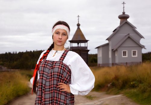 Russian girl in national dress on a background of the church
