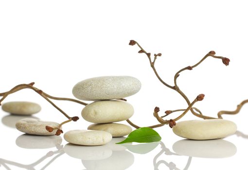 Spa stones and green leaf, isolated on white background.