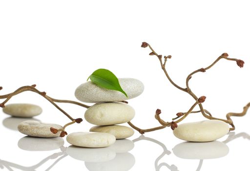 Spa stones and green leaf, isolated on white background.