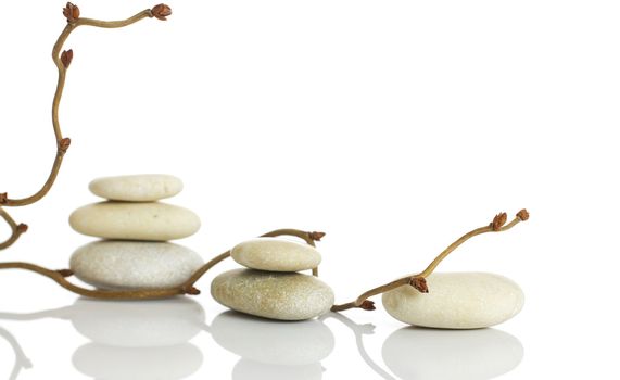 Spa stones and dry hazel branches, isolated on white background.