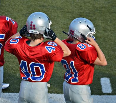 CUMMING, GA/USA - SEPTEMBER 8: Andy Leggett and an unidentified boy getting ready to go into a football game. A team of 7th grade boys September 8, 2012 in Cumming GA. The Wildcats  vs The Mustangs.