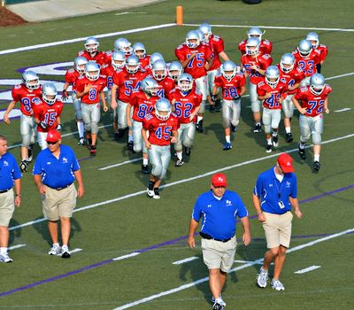 CUMMING, GA/USA - SEPTEMBER 8: A 7th grade football team and coaches on the field.  September 8, 2012 in Cumming GA. The Wildcats  vs The Mustangs.