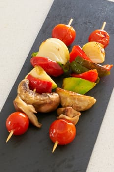 Vegetable brochettes on a black slate tray
