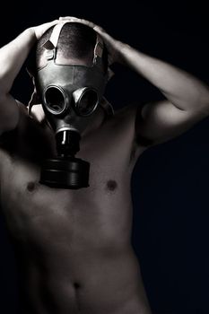 Naked man with protective gas mask, pain, fear, dark