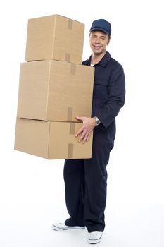 Smiling delivery guy carrying cardboard boxes, full length portrait