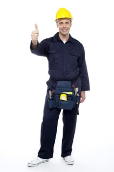 Young smiling industrial engineer showing thumbs up over white background