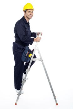 Industrial employee stepping up the ladder and looking at you