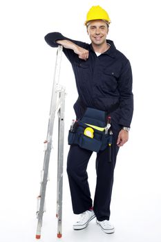 Full length portrait of industrial engineer resting his hands on stepladder