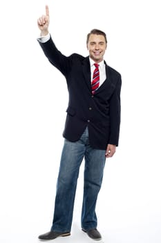 Tall and smart business representative posing with his finger raised... Please, May I ?